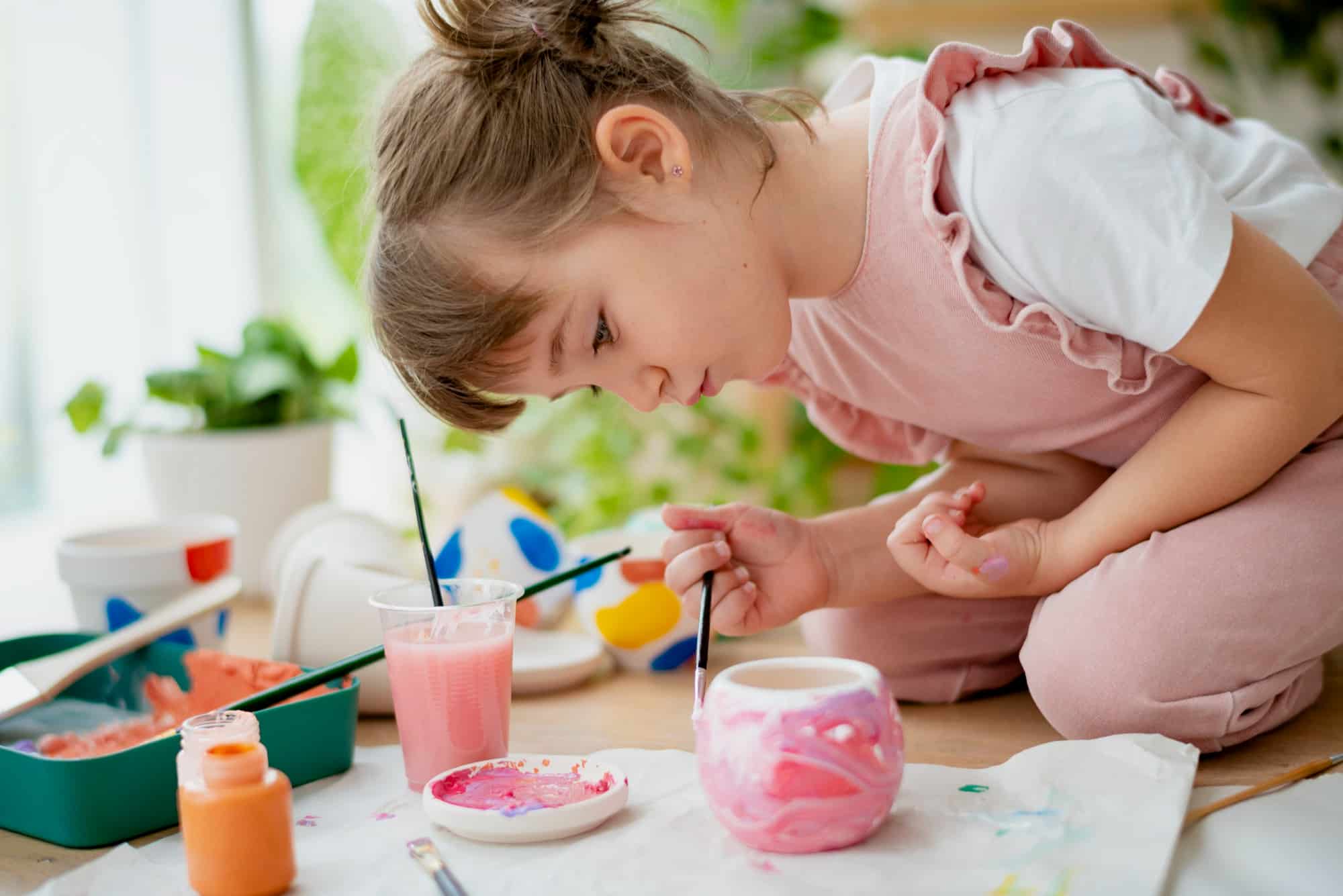 enfant en train de peindre pot de fleurs