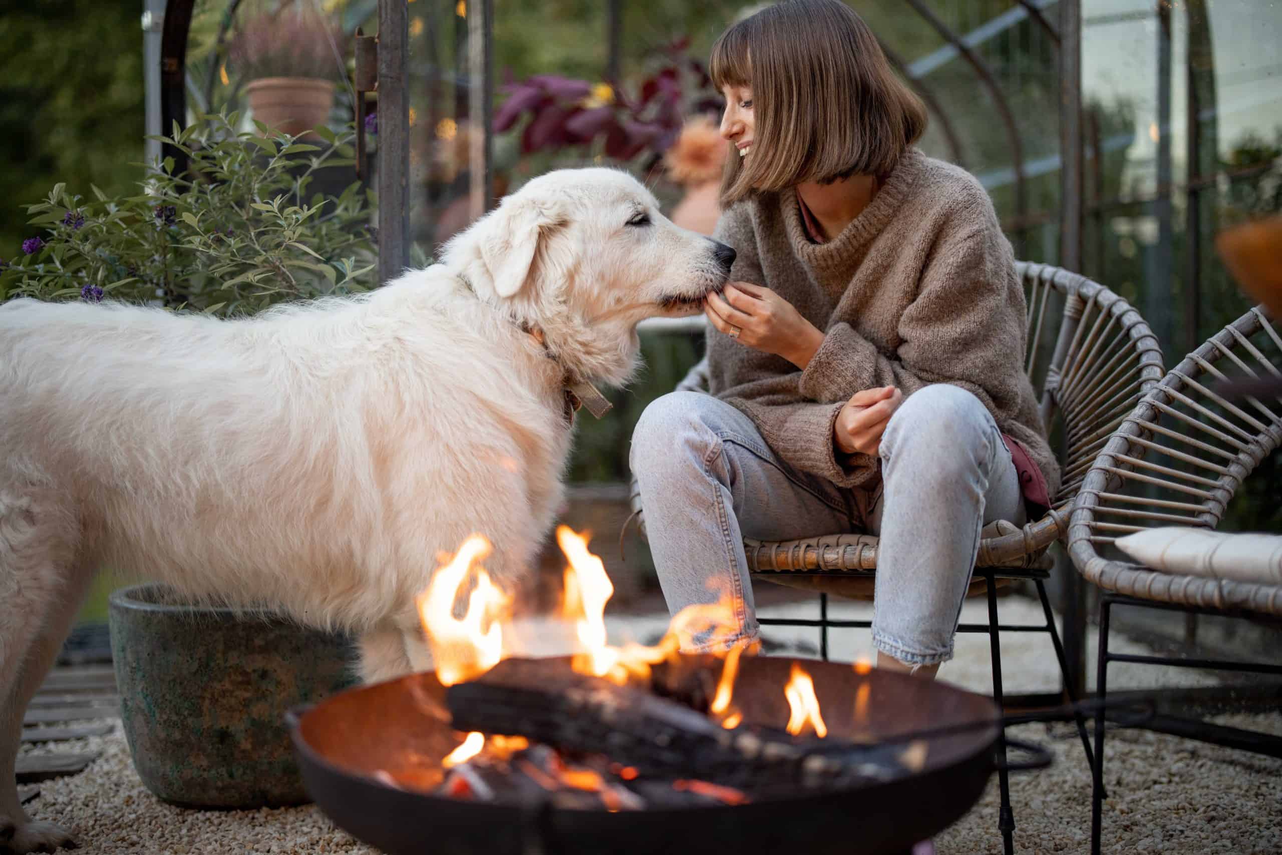 vrouw en hond buiten aan vuurkorf